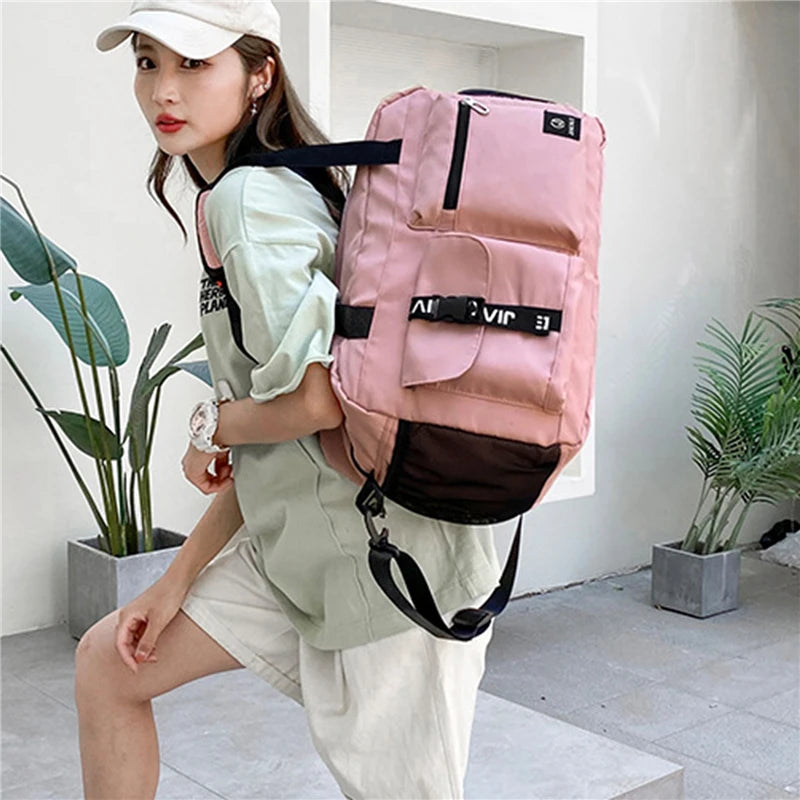 Pink women's travel handbag backpack with multiple pockets worn by woman in casual outfit