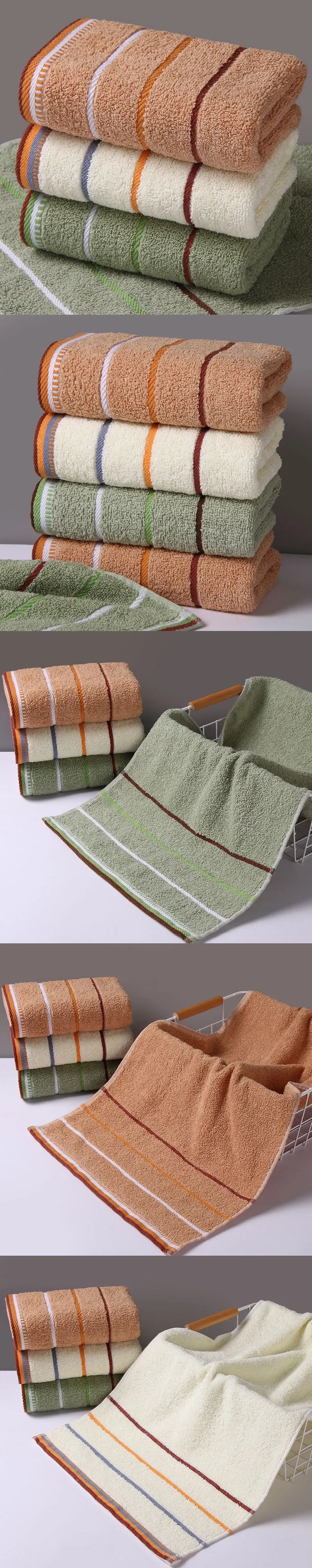 Stack of pure cotton bath towels in orange, green, and beige with striped design on countertop