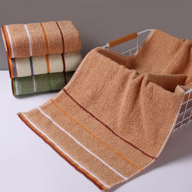 Stack of colorful pure cotton bath towels with striped edges and soft texture