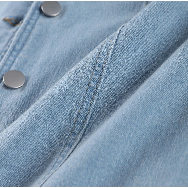 Close-up of light blue fabric and metal buttons on women's jean long dress by Maxim Trends