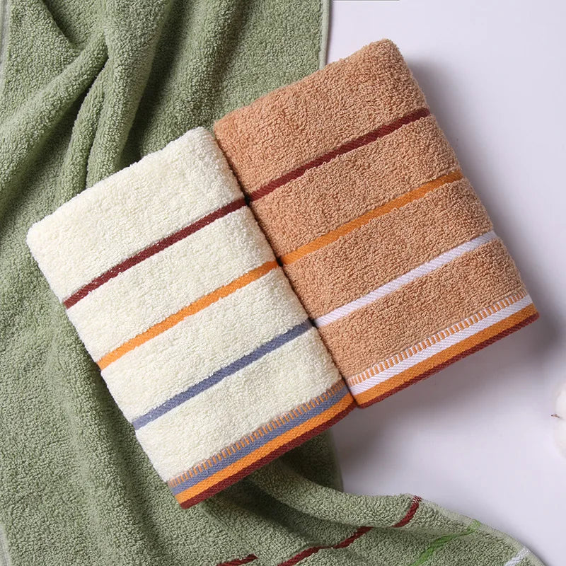 AliExpress pure cotton bath towels in beige and white with colorful stripes on green towel background