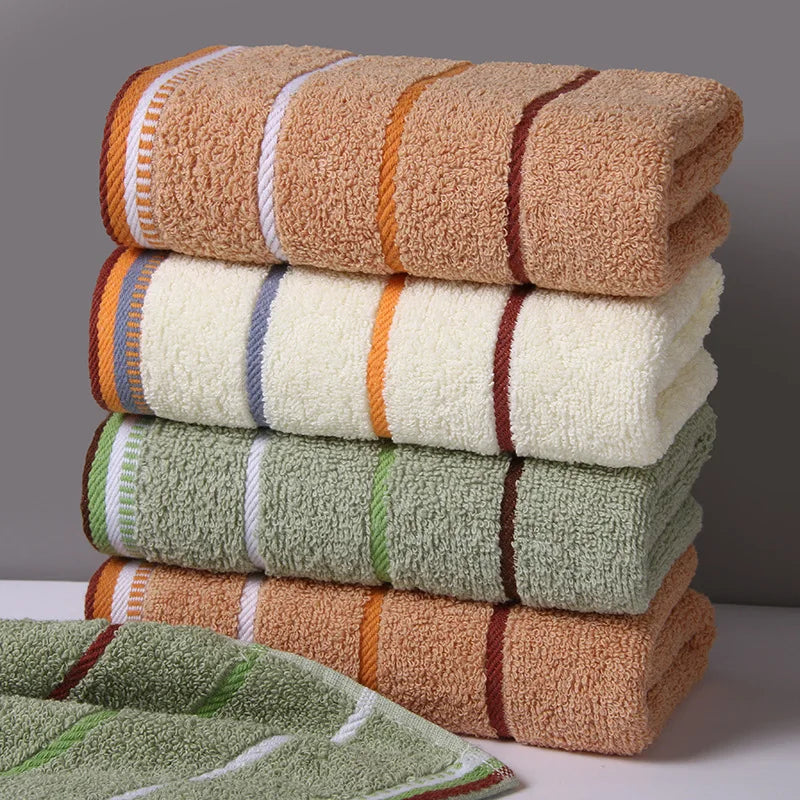 Stack of AliExpress pure cotton bath towels in beige, white, and green with striped edges