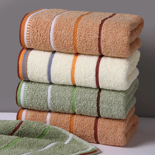 Stack of AliExpress pure cotton bath towels in beige, white, and green with striped edges
